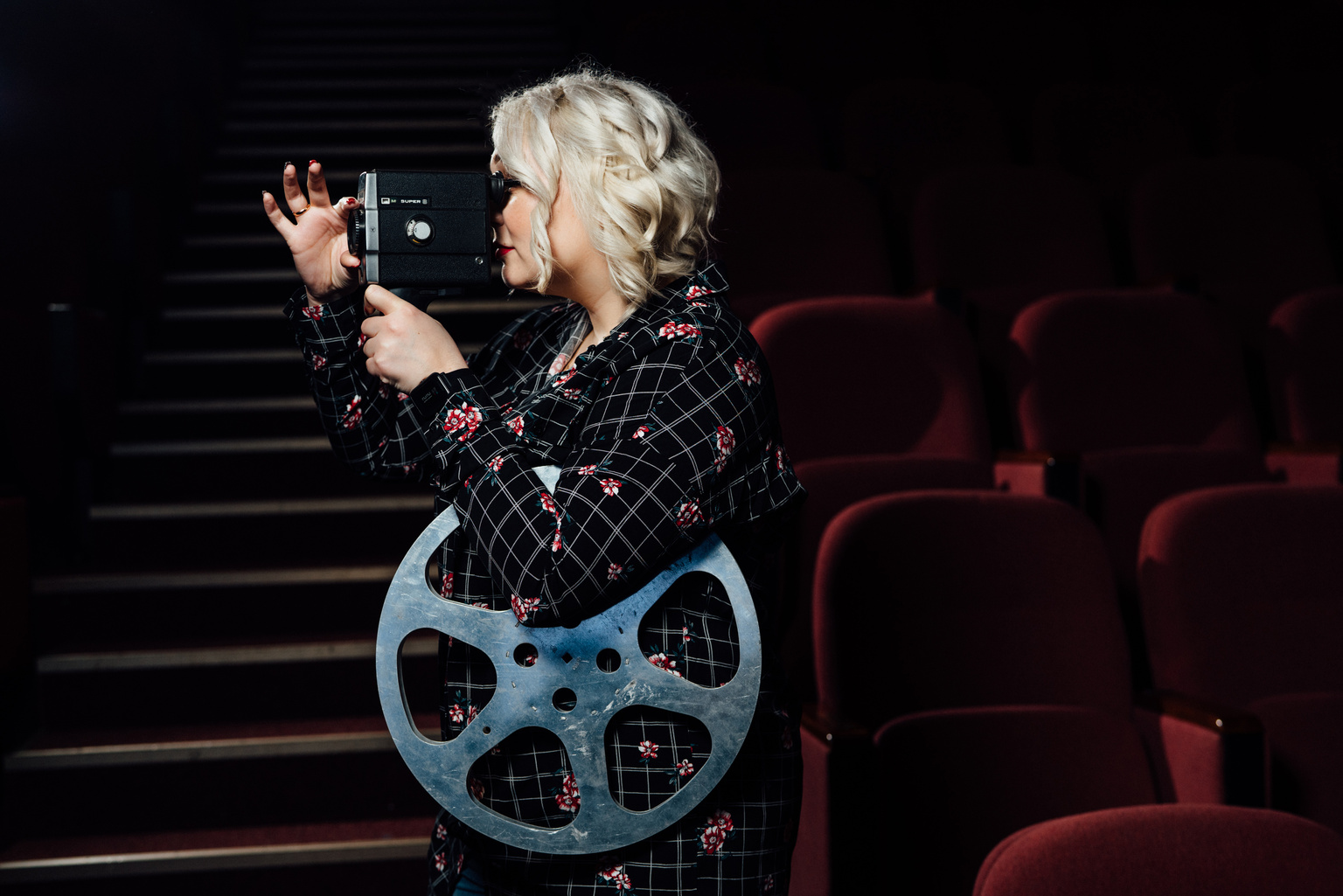 Woman with Camera and Film in Movie Theater